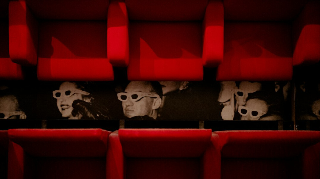 Empty cinema screen with rows of red seats